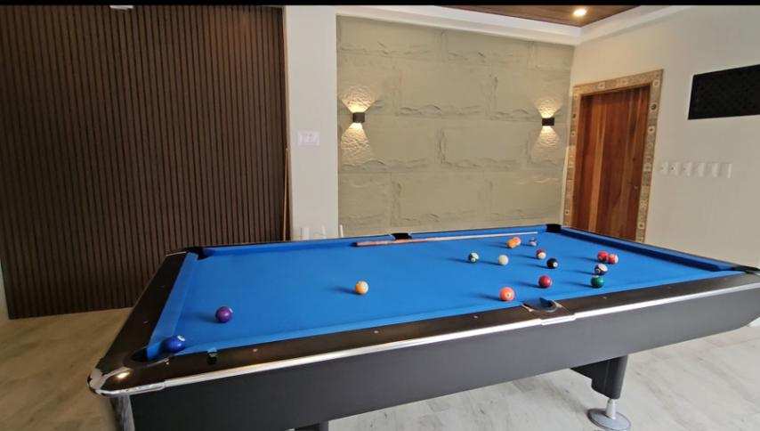 Blue-felt billiards table with scattered balls in the indoor recreation area.