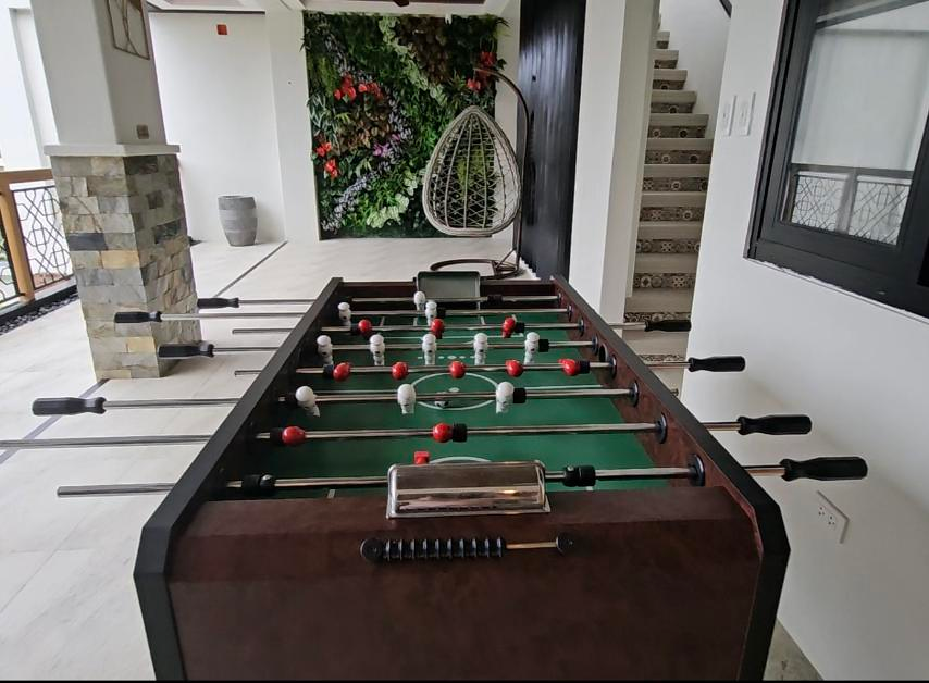 Foosball table with red and white players beside the lounge and staircase.
