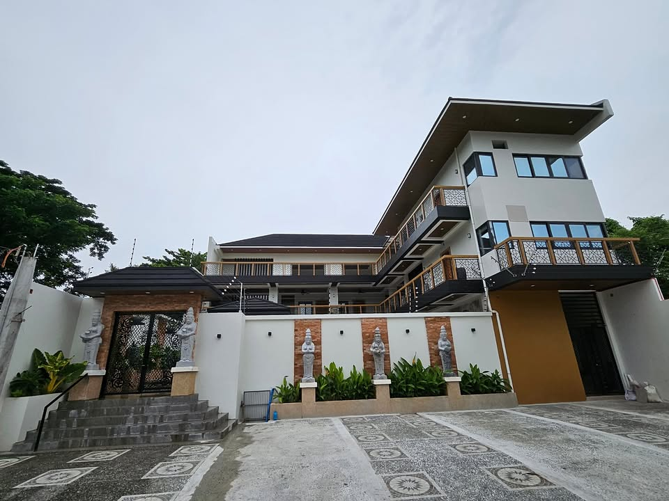 Wide exterior view of Serenity showing the balconies, decorative entrance and paved forecourt.